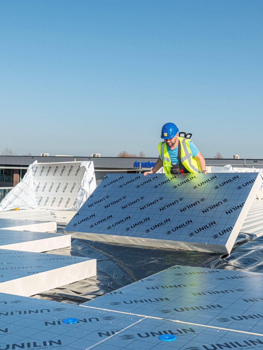 Installation de panneaux Unilin Utherm par un professionnel pour l'isolation thermique par l'extérieur (ITE) d'un toit plat.